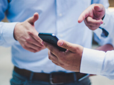 Personne qui montre quelque chose sur son téléphone à un collègue.