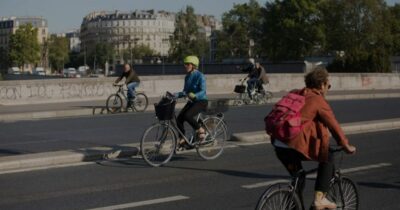 On peut voir des cyclistes en ville qui pédalent sur la route.