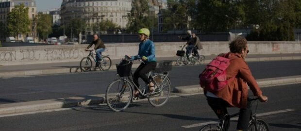 On peut voir des cyclistes en ville qui pédalent sur la route.