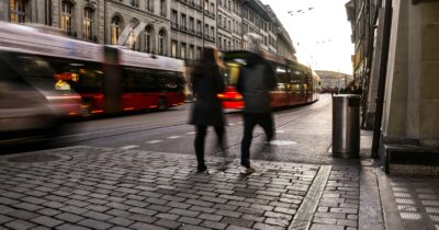 Des personnes qui marchent au milieu du trafic urbain.