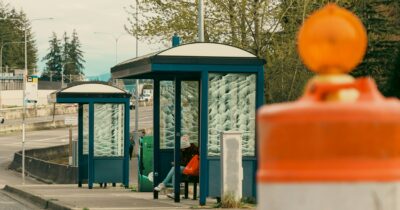 Une jeune fille attendant à un arrêt de bus en ville.