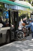 Bus avec rampe PMR pour permettre une dame à mobilité réduite de monter à l'intérieur.