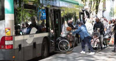 Bus avec rampe PMR pour permettre une dame à mobilité réduite de monter à l'intérieur.