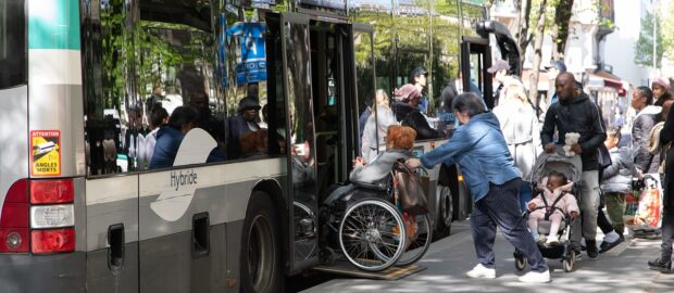 Bus avec rampe PMR pour permettre une dame à mobilité réduite de monter à l'intérieur.
